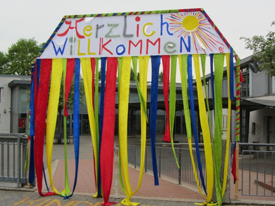 Ein selbstgebautes Herzliche Willkommen Tor am Eingang des Schulhofs