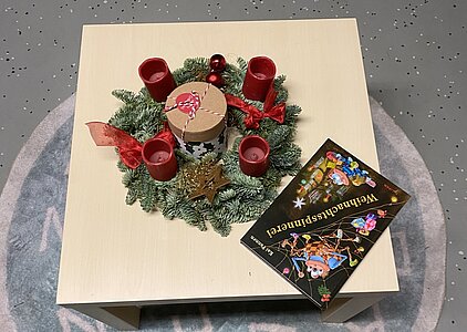 Adventskranz und Buch auf Tisch